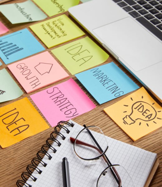 paper stickers with business strategy, laptop and notebook with pencil on tabletop